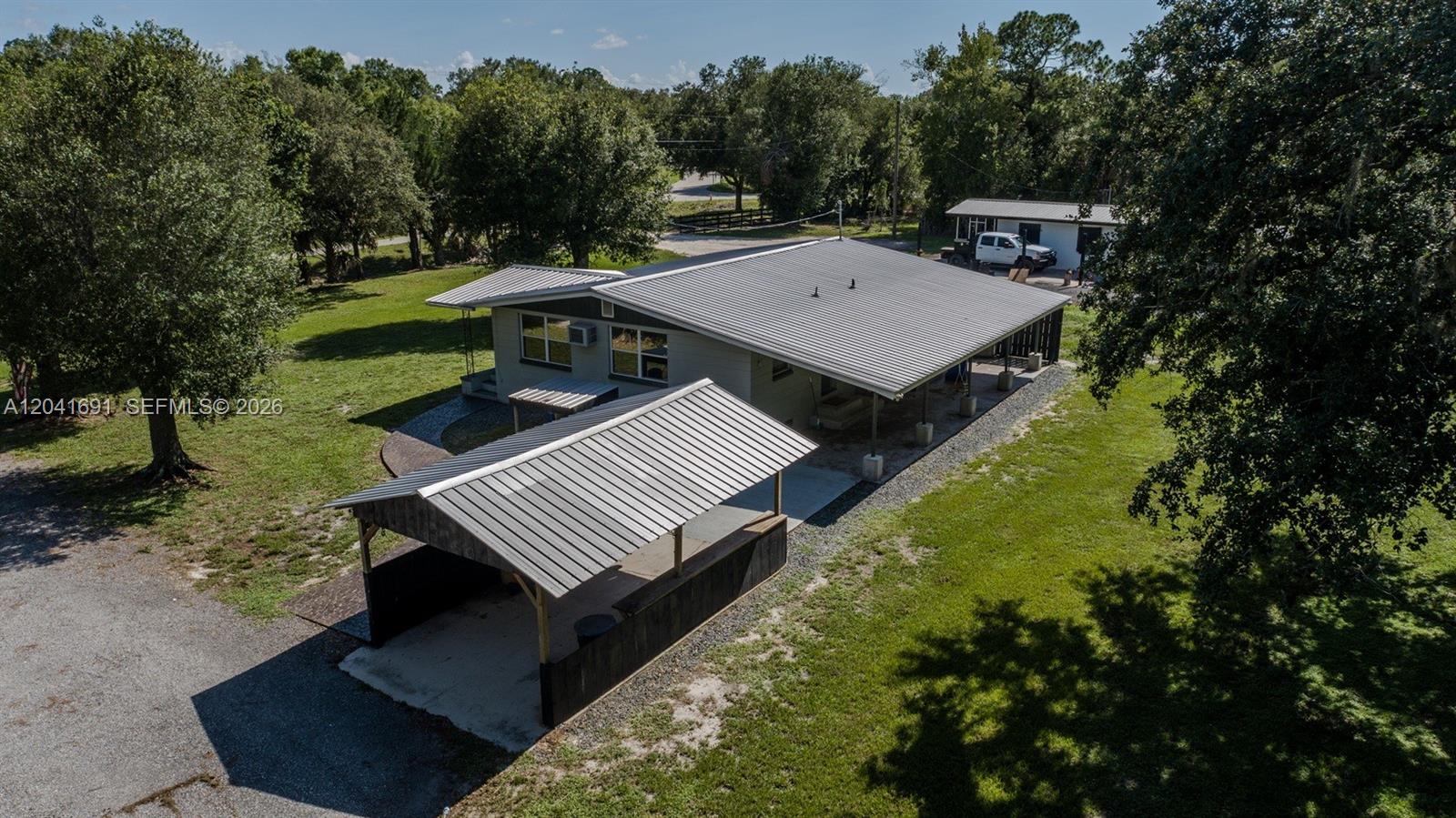 1270 Nobles Road LaBelle, FL 33935 - Photo 3 of 18 a view of a patio with table and chairs with wooden floor and fence
