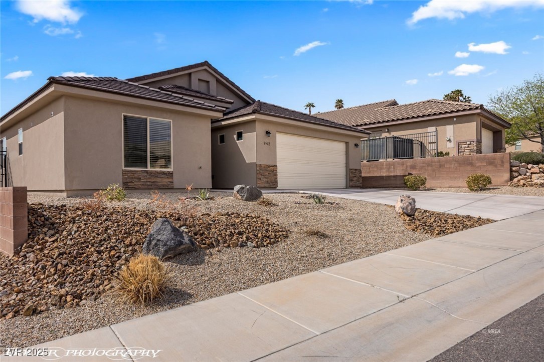 942 Shadow Hawk Ridge Mesquite, NV 89027 - Photo 2 of 67 Ranch-style house featuring a garage, stucco siding, concrete driveway, and stone siding