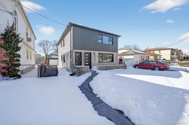 a front view of a building with cars parked