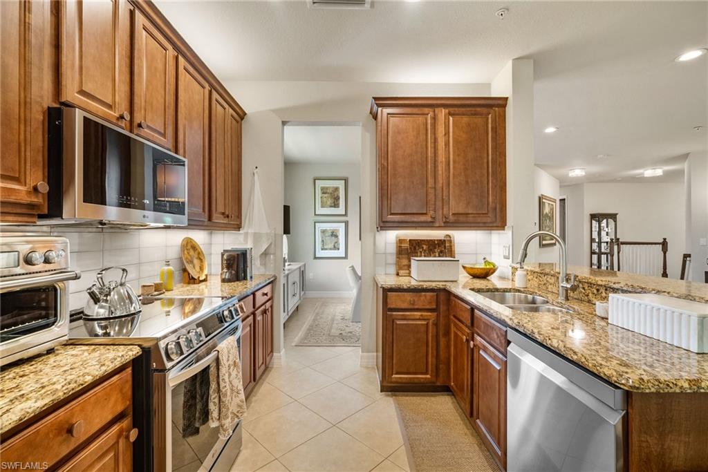 6510 Monterey Point, Unit 204 Naples, FL 34105 - Photo 9 of 48 a kitchen with stainless steel appliances granite countertop a stove top oven a sink dishwasher and cabinets with wooden floor