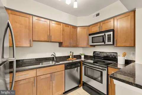 a kitchen with stainless steel appliances granite countertop a sink stove and microwave