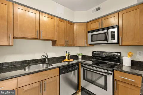 a kitchen with stainless steel appliances granite countertop a stove a microwave and a sink