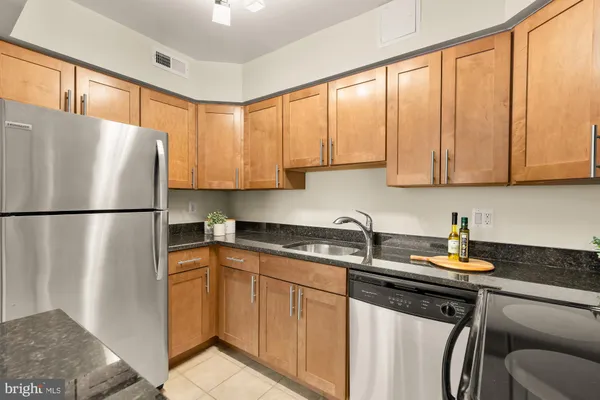 a living room with stainless steel appliances furniture refrigerator and a window