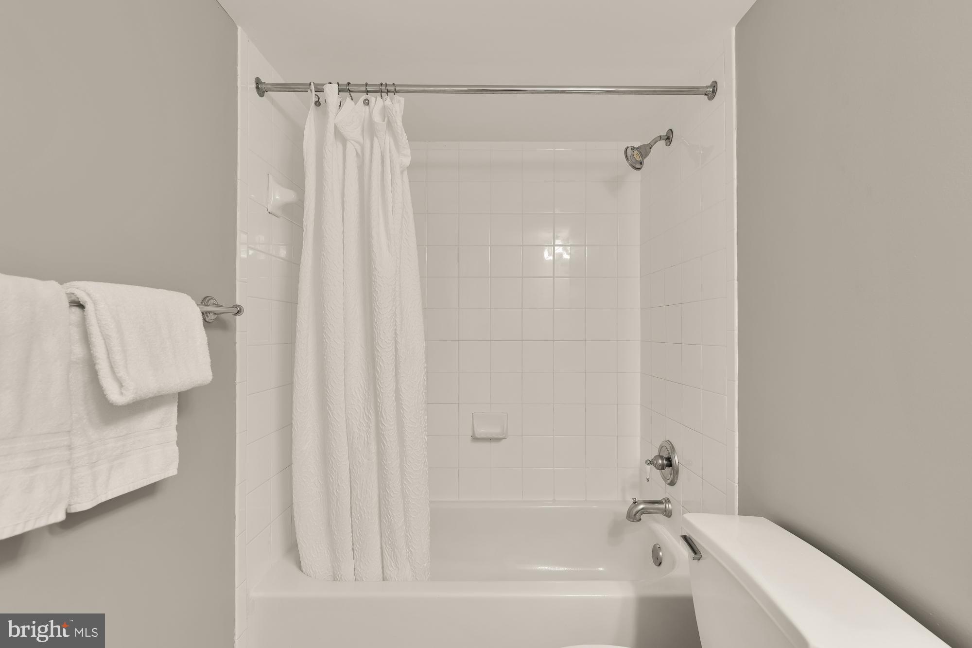 3804 Rodman Street Northwest, Unit 303 Washington, DC 20016 - Photo 25 of 33 a bathroom with a shower curtain and a bathtub