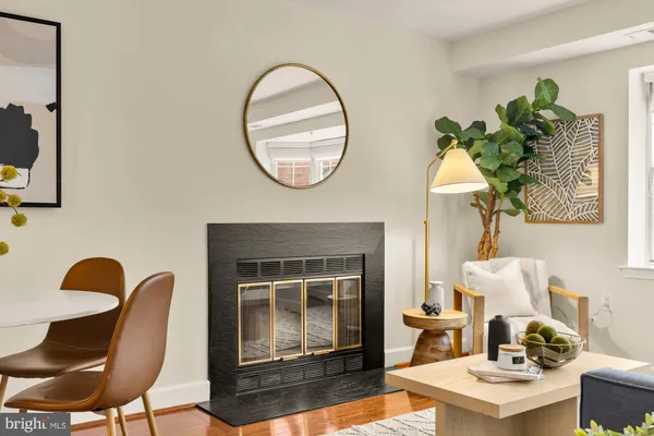 a living room with furniture a fireplace and a large window
