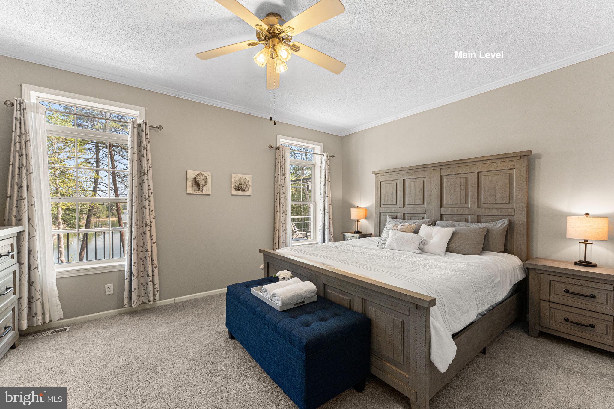 249 Spring Hill Road Lancaster, VA 22503 - Photo 19 of 65 a bedroom with a bed and a chandelier