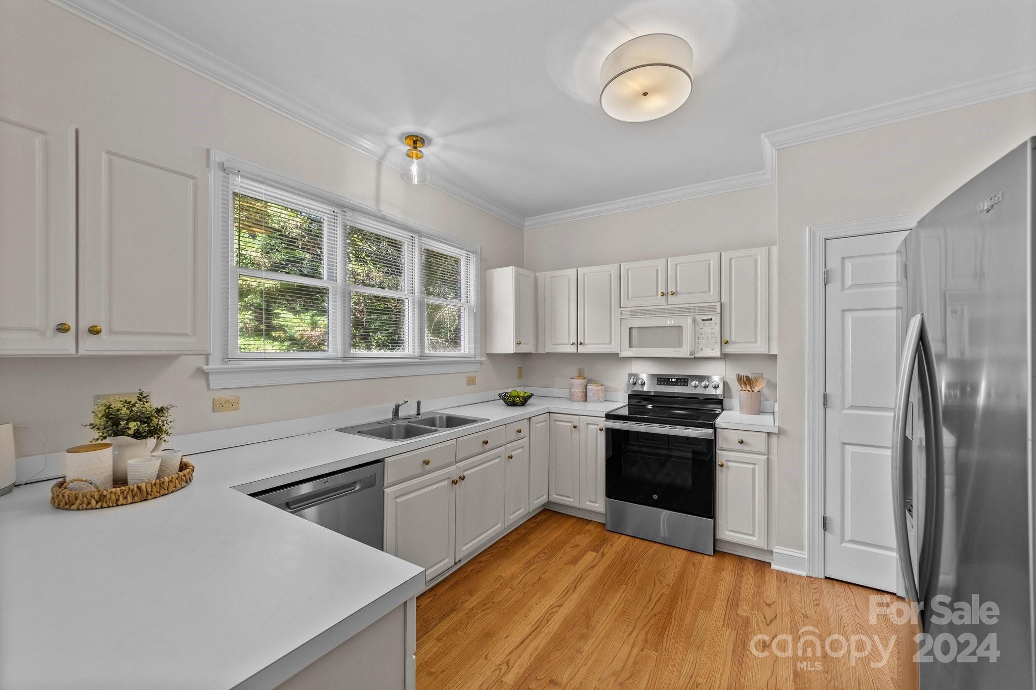 101 North Kimberly Road Davidson, NC 28036 - Photo 18 of 38 a kitchen with a sink appliances cabinets and a window