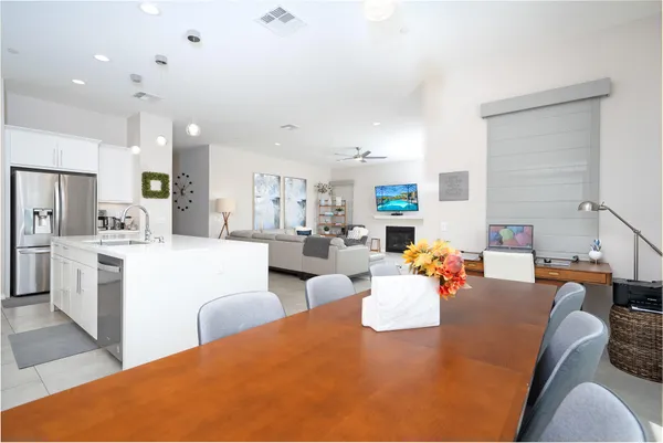 a living room with fireplace furniture and a view of kitchen