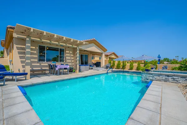 a view of a house with swimming pool and sitting area