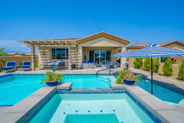 a view of a house with swimming pool having outdoor seating