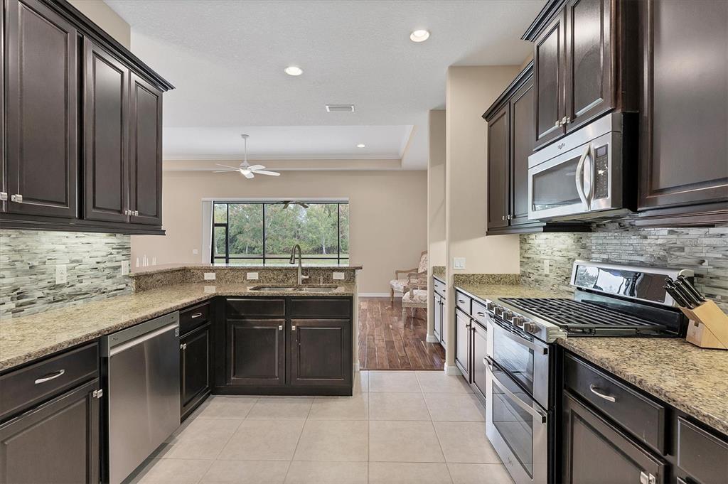 7909 Rio Bella Place Bradenton, FL 34201 - Photo 7 of 34 a kitchen with stainless steel appliances granite countertop a sink stove and cabinets