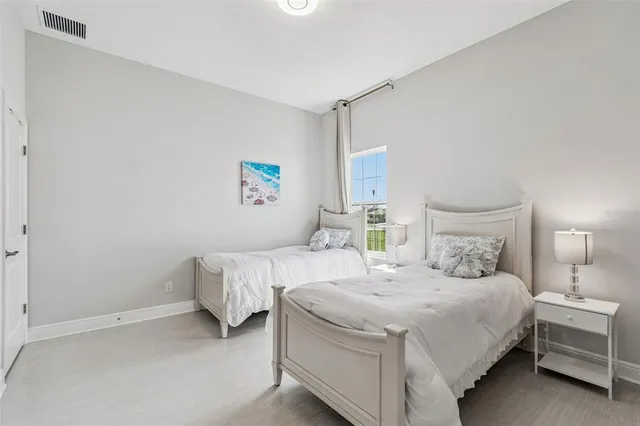 a bedroom with a bed lamp and a large window