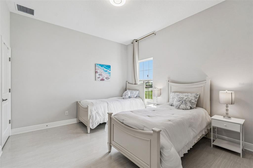 10863 Rustic Timber Loop San Antonio, FL 33576 - Photo 20 of 56 a bedroom with two beds and a lamp on the dresser