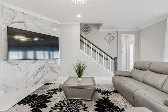 a living room with furniture kitchen view and a large window