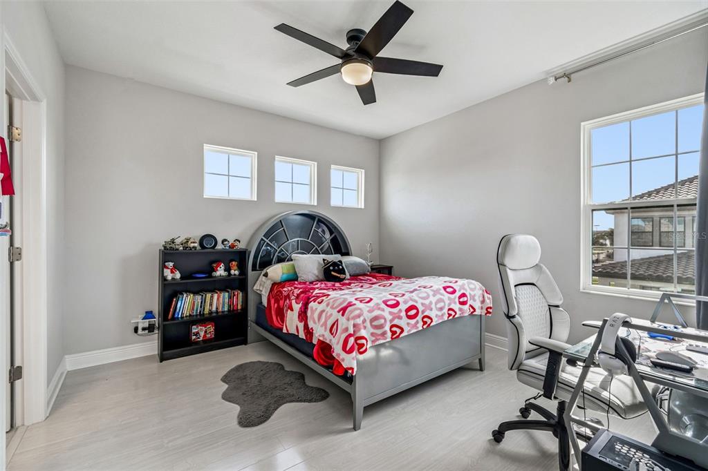 10863 Rustic Timber Loop San Antonio, FL 33576 - Photo 31 of 56 a bedroom with a bed and a chandelier