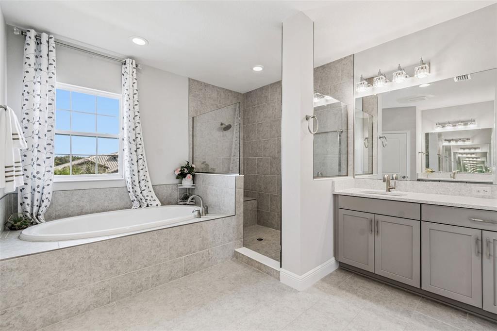 10863 Rustic Timber Loop San Antonio, FL 33576 - Photo 40 of 56 a spacious bathroom with a double vanity sink a mirror and a shower
