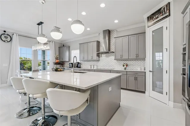 a large white kitchen with lots of counter space a sink and appliances