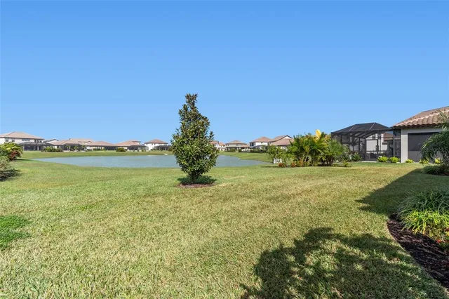 a view of a house with a yard and lake view