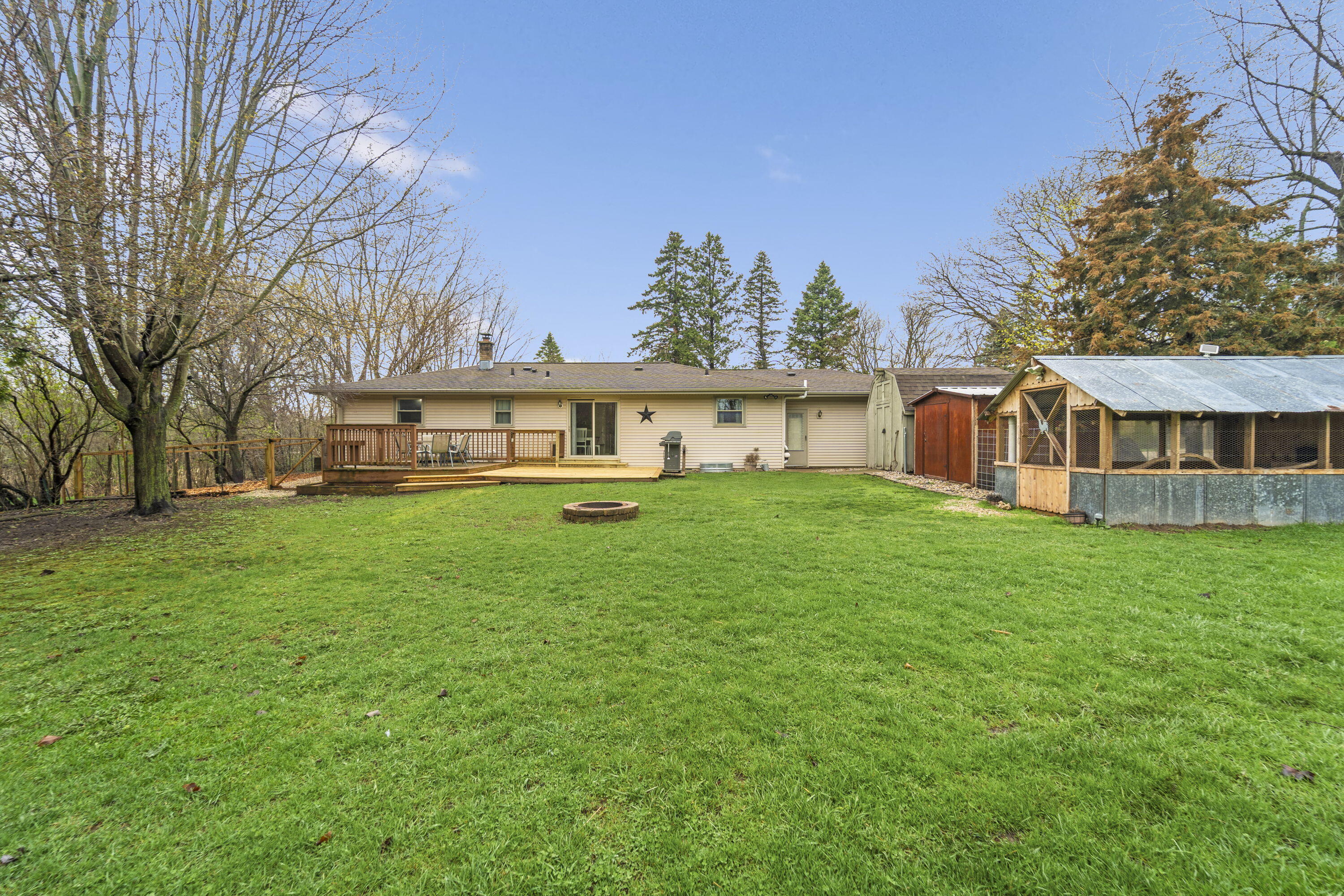 827 South Fancher Road Mount Pleasant, WI 53406 - Photo 22 of 26 Full rear view showcasing deck, yard, and additional outbuildings for storage or hobbies.