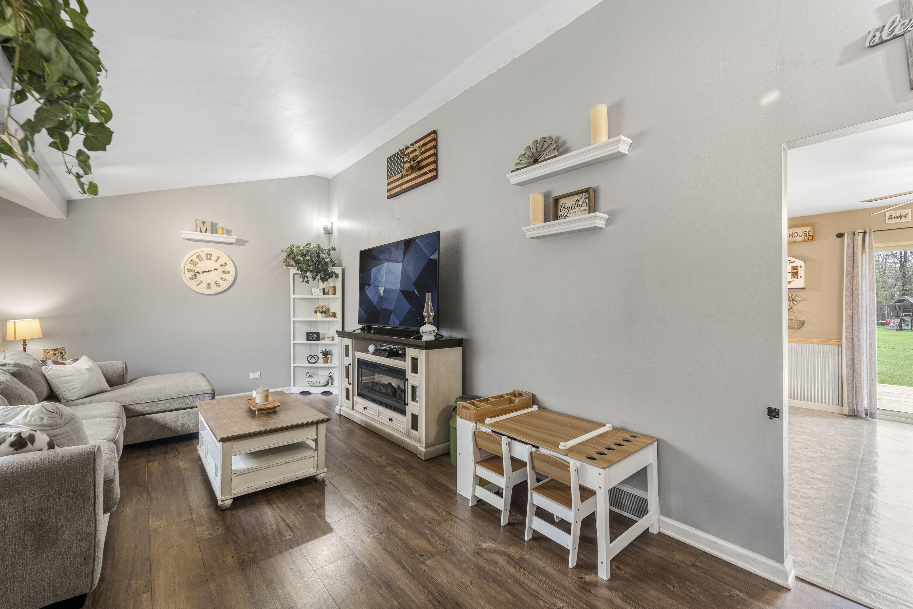 827 South Fancher Road Mount Pleasant, WI 53406 - Photo 4 of 26 Light-filled living room with large picture window, warm flooring, and comfortable layout.