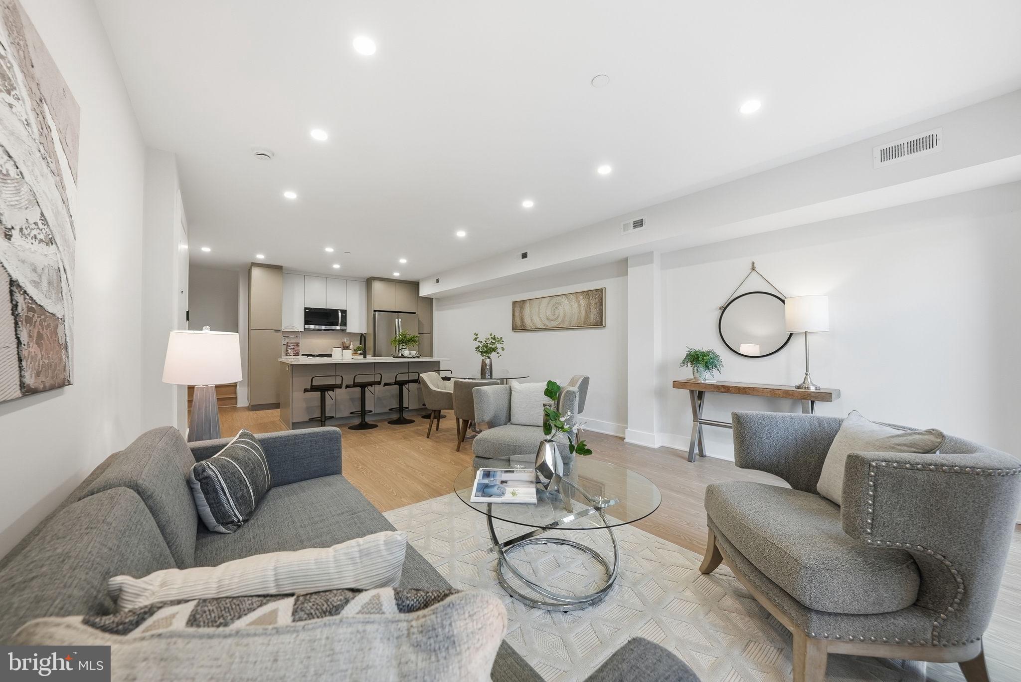 a living room with furniture kitchen view and a window