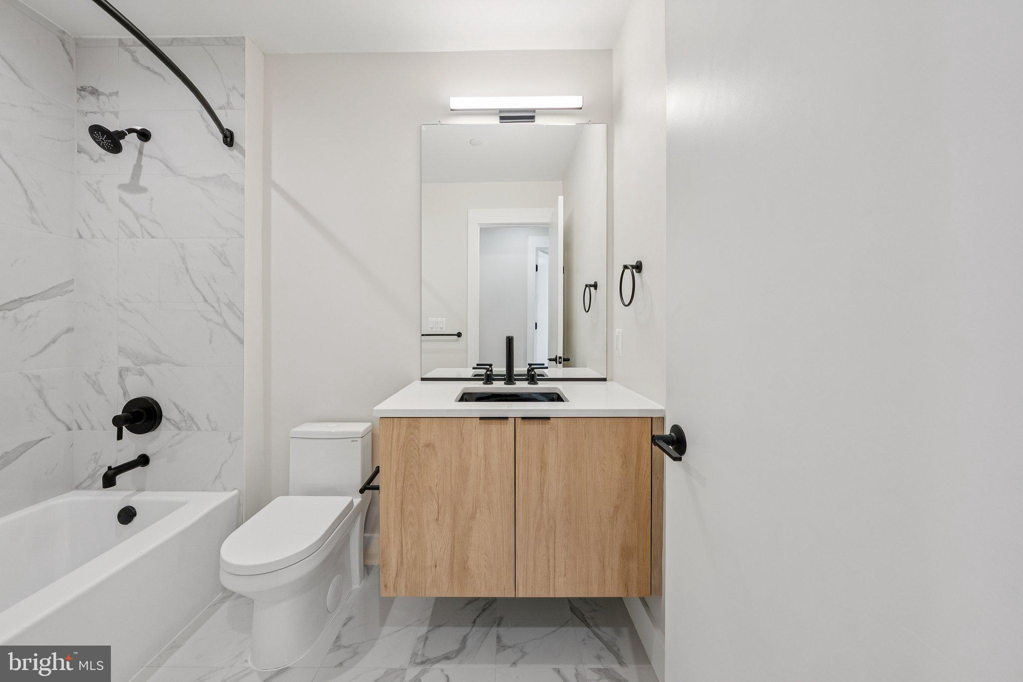 2134 Wisconsin Avenue Northwest, Unit 4 Washington, DC 20007 - Photo 17 of 32 a bathroom with a sink a toilet a mirror and shower