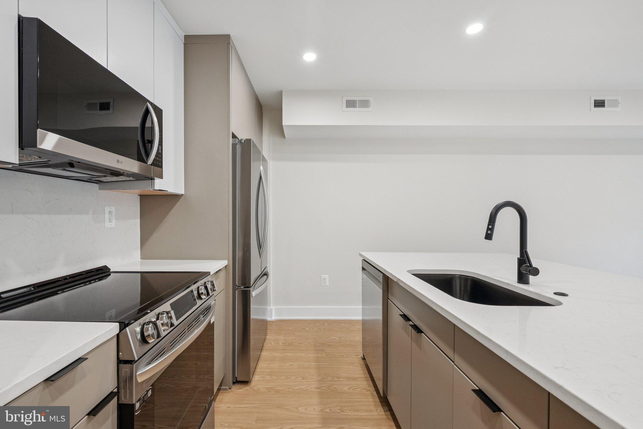 2134 Wisconsin Avenue Northwest, Unit 4 Washington, DC 20007 - Photo 5 of 32 a kitchen that has a sink and a stove in it
