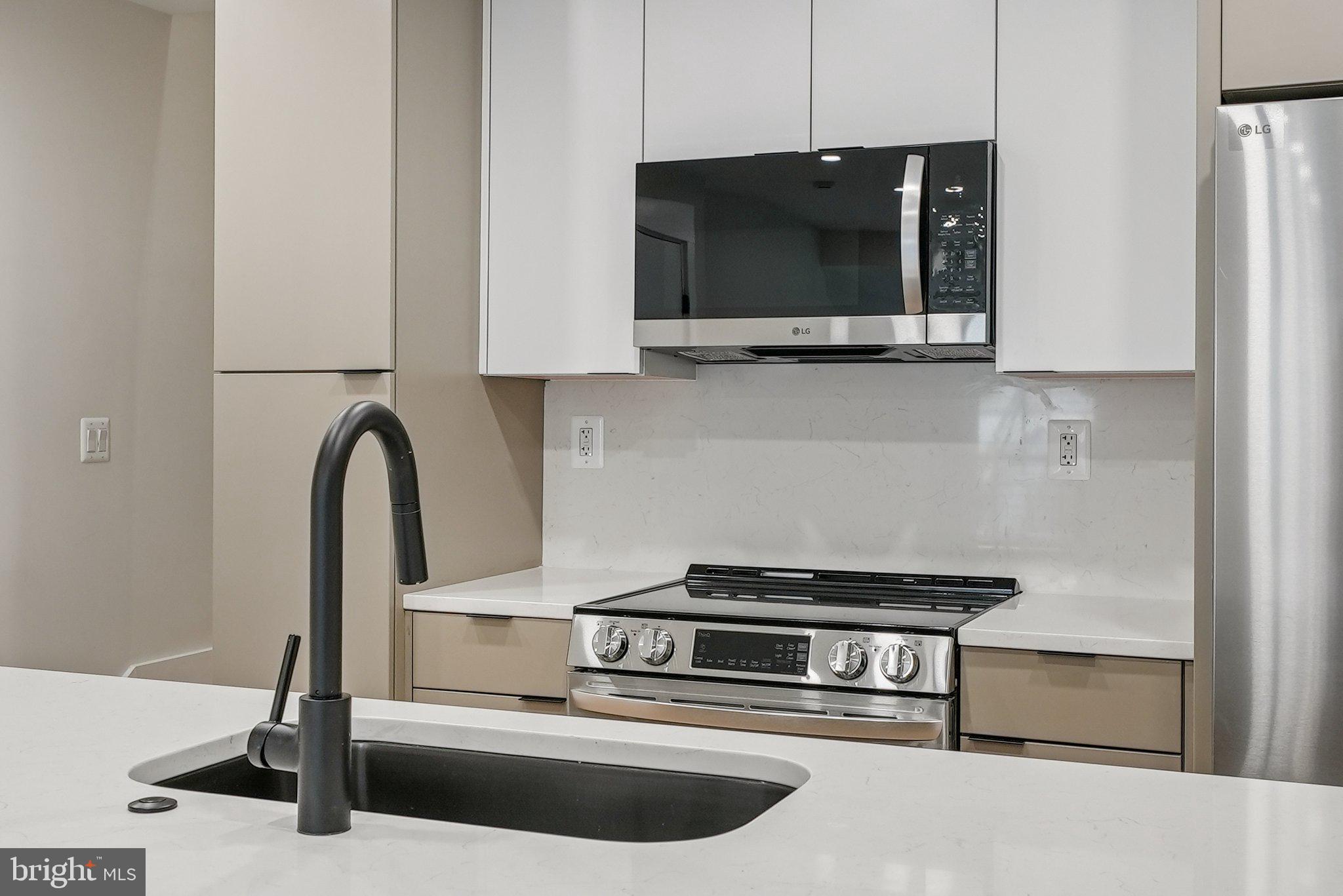 2134 Wisconsin Avenue Northwest, Unit 4 Washington, DC 20007 - Photo 7 of 32 a kitchen with a stove and a microwave