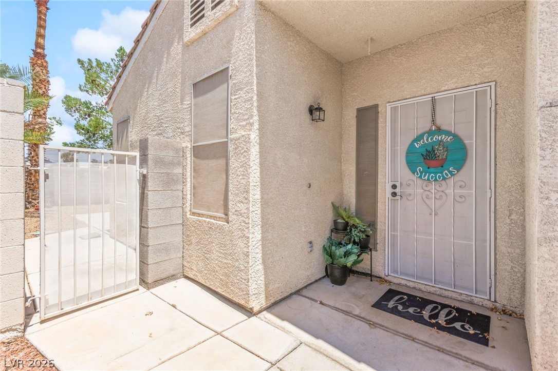 7353 Ridge Star Court Las Vegas, NV 89131 - Photo 7 of 36 Secure entry to a charming home, featuring a robust security gate and textured stucco exterior.