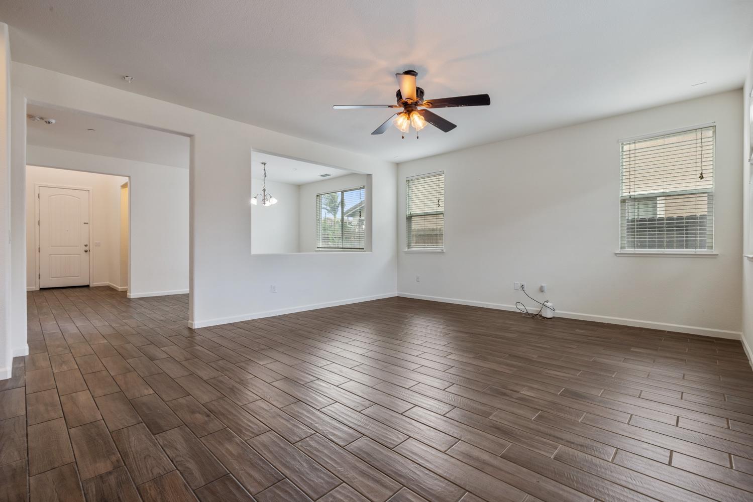 1513 Rock Spring Avenue Manteca, CA 95337 - Photo 15 of 56 a view of a livingroom with wooden floor and a ceiling fan