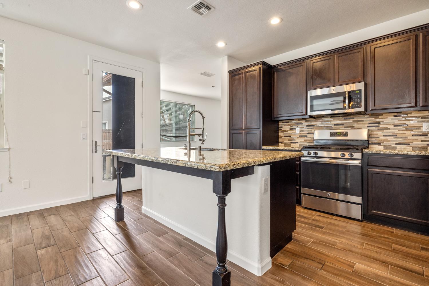 1513 Rock Spring Avenue Manteca, CA 95337 - Photo 17 of 56 a kitchen with stainless steel appliances granite countertop a sink stove and refrigerator