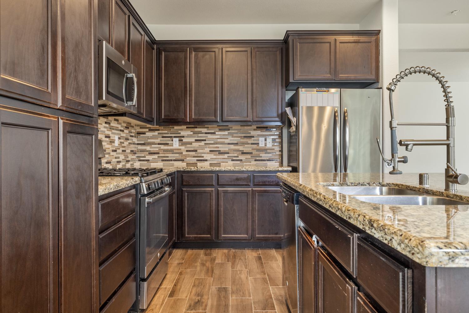 1513 Rock Spring Avenue Manteca, CA 95337 - Photo 18 of 56 a kitchen with stainless steel appliances granite countertop a sink stove and cabinets