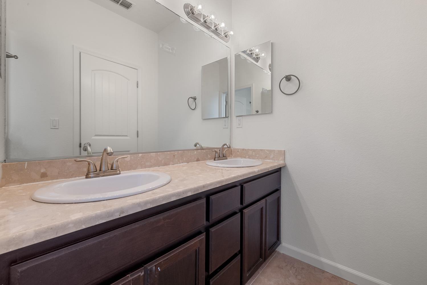1513 Rock Spring Avenue Manteca, CA 95337 - Photo 40 of 56 a bathroom with a granite countertop sink and a mirror