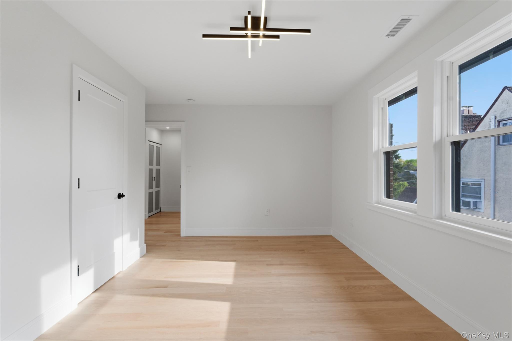 40 Calhoun Avenue New Rochelle, NY 10801 - Photo 18 of 49 Open room featuring light wood-finish flooring and bright white walls