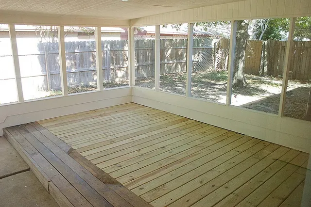 a view of empty room with wooden floor and floor to ceiling window
