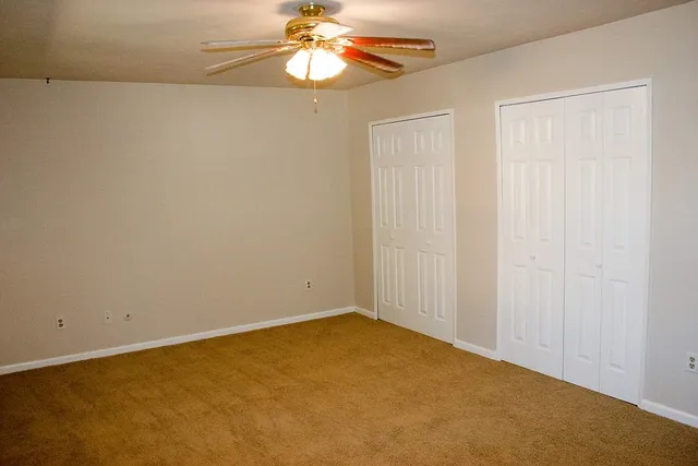 an empty room with a chandelier fan