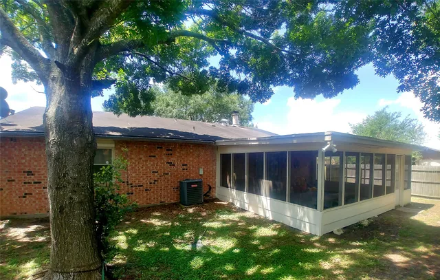 a view of a house with a small yard and a large tree