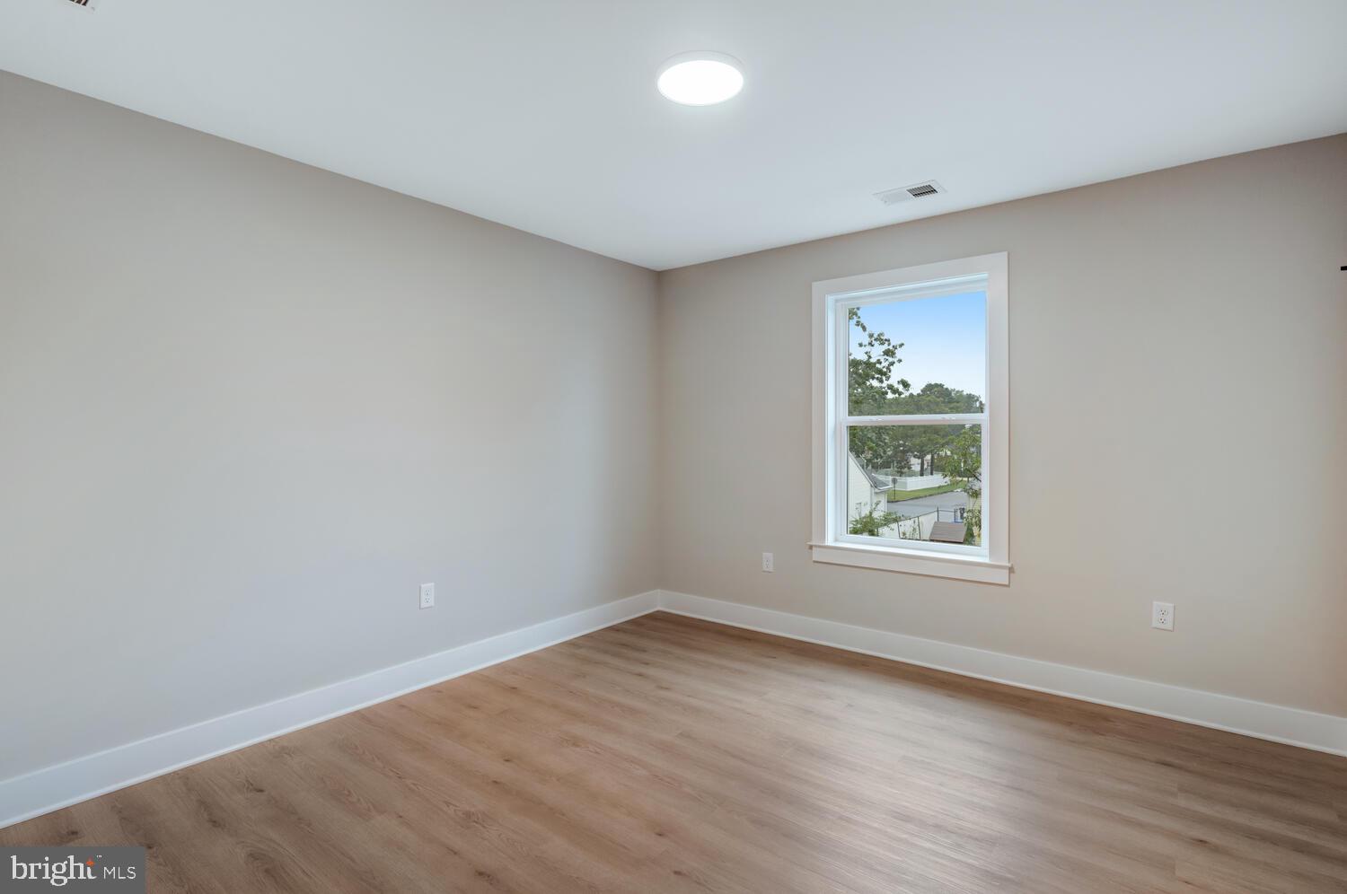 264 Schooner Road Manahawkin, NJ 08050 - Photo 22 of 37 an empty room with wooden floor and windows
