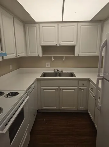 a kitchen with white cabinets and a sink