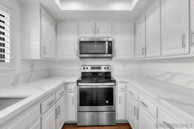 a kitchen with cabinets stainless steel appliances and a sink