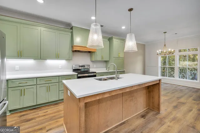 a kitchen with a sink a stove and a wooden floor
