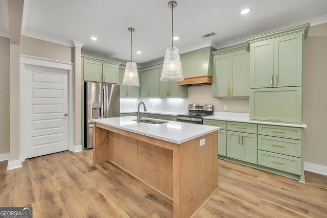 a kitchen with kitchen island a sink stainless steel appliances and cabinets
