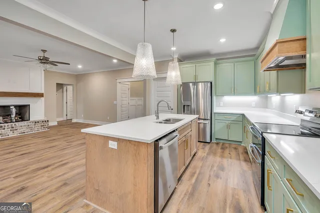 a kitchen with stainless steel appliances granite countertop a sink a stove and a refrigerator