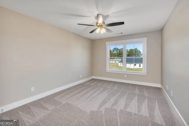 an empty room with a window and a ceiling fan