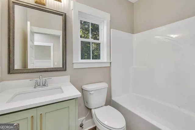 a bathroom with a granite countertop toilet a sink and a bathtub