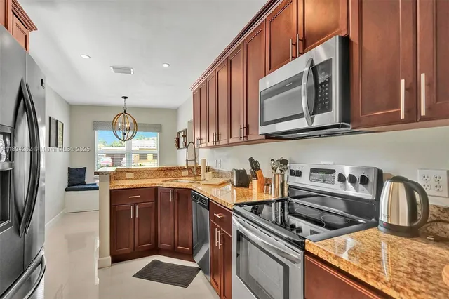 a kitchen with stainless steel appliances granite countertop a sink stove and refrigerator