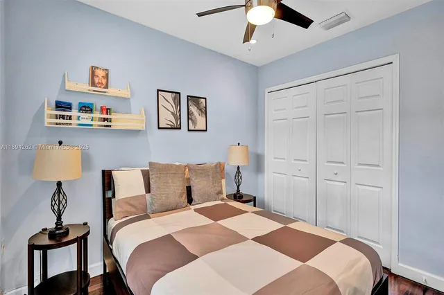 a bedroom with a bed and a lamp on table and chair