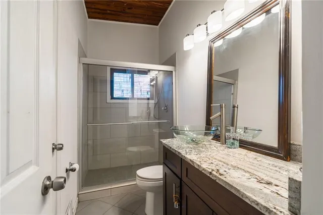 a bathroom with a granite countertop sink toilet and shower