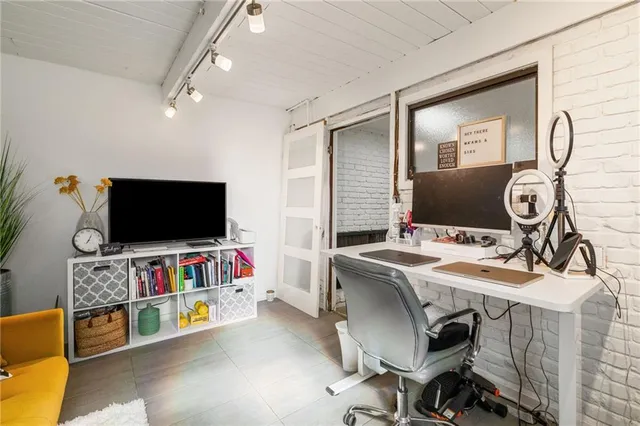a view of a livingroom with workspace and a flat screen tv