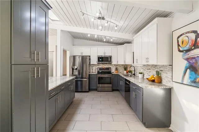 a kitchen with stainless steel appliances granite countertop a refrigerator and a stove top oven